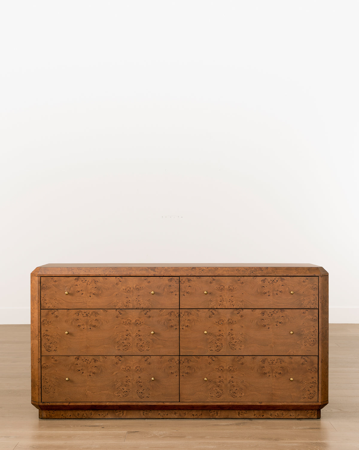 Commode artisanale en bois madré avec poignées en laiton et motifs géométriques pour chambre à coucher